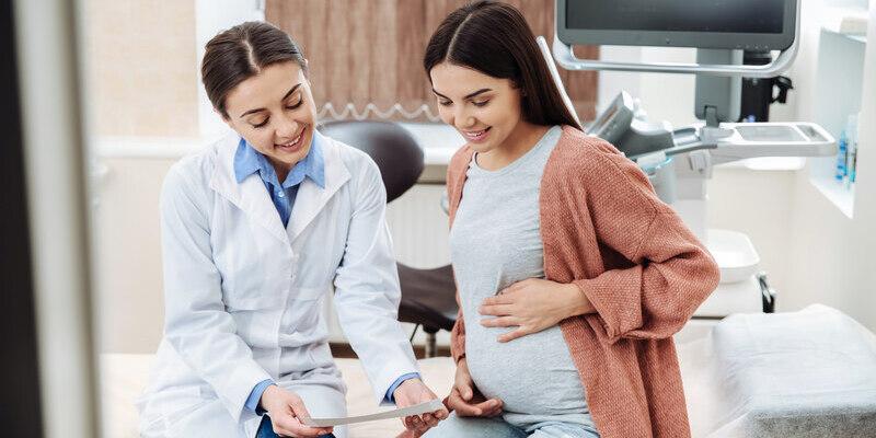 Badania genetyczne w ciąży - na zdjęciu kobieta w ciąży podczas konsultacji lekarskiej.