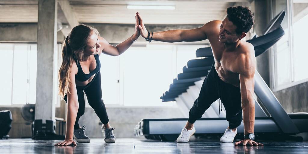 przetrenowanie - kobieta i mężczyzna ćwiczący na siłowni
