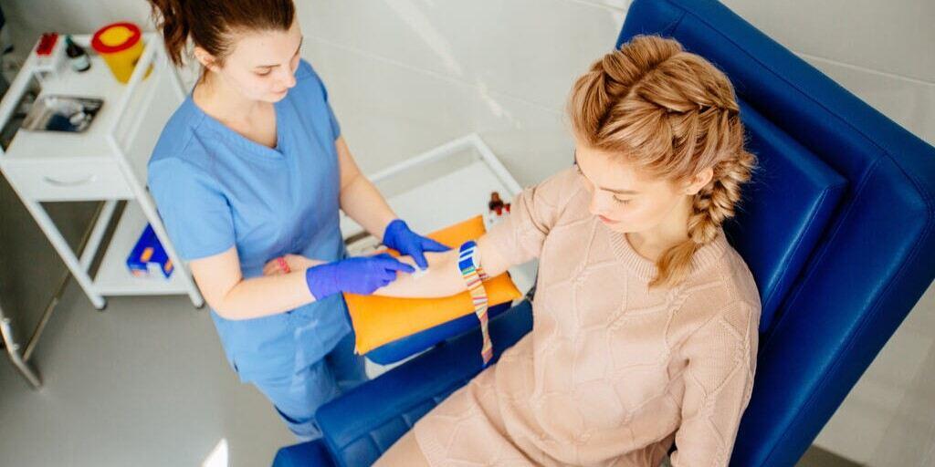 Gonadotropina kosmówkowa - zdjęcie przedstawia kobietę, która jest przygotowywana przez pielęgniarkę do pobierania krwi