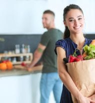 Young couple in the kitchen , woman with a bag of groceries shop